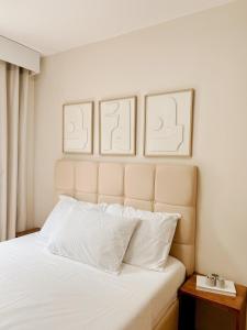 a bedroom with a bed with two pictures on the wall at 2BR Condo w Pool & WiFi Near Mall & Restaurants in Lapasan +26 photos