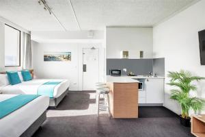 a hotel room with two beds and a kitchen at Metro Hotel Miranda in Miranda