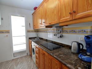 een keuken met houten kasten en een spoelbak bij Sunny Stay, Orihuela Costa in Villamartin
