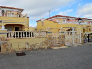 een geel huis met een hek en een hek bij Sunny Stay, Orihuela Costa in Villamartin