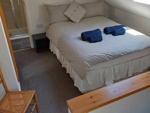 a small bed with two blue pillows on it at The Sidings in Matlock