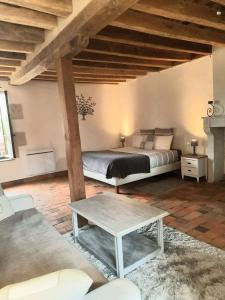 a bedroom with a bed and a coffee table at Moulin de Janlard in Nannay