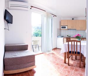ein Wohnzimmer mit Tisch und Küche in der Unterkunft Apartment Sangaleti in Lastovo