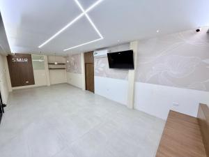 a large empty room with a flat screen tv on a wall at Hotel SMIR, Huaquillas in Huaquillas