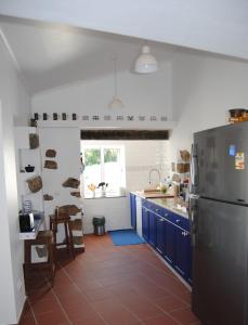 eine Küche mit blauen Schränken und einem Kühlschrank in der Unterkunft Casa da Malta in Livramento