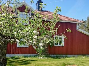 a red house with a tree in front of it at 5 person holiday home in GAMLEBY in Karrum