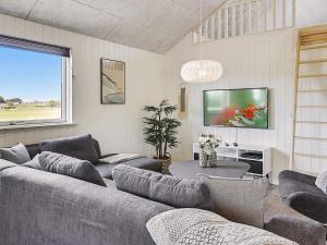 a living room with a couch and a tv at 5 star holiday home in Stege in Stege