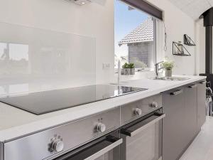 a white kitchen with a sink and a window at 5 star holiday home in Stege in Stege