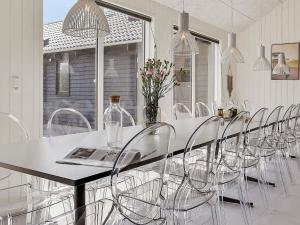 a white dining room with a table and chairs at 5 star holiday home in Stege in Stege