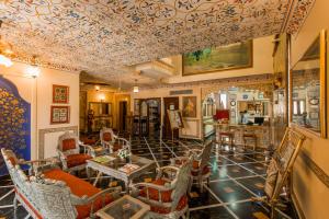 salon z kasetonowym sufitem i krzesłami w obiekcie Umaid Mahal - A Heritage Style Boutique Hotel w mieście Dżajpur