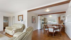 a living room with white furniture and a dining room at White Springs, Our Peaceful Holiday House In Coffin Bay in Coffin Bay