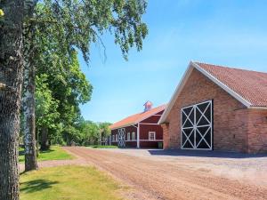 a red barn with a large door on a dirt road at 6 person holiday home in HOVA-By Traum in Hova +20 photos