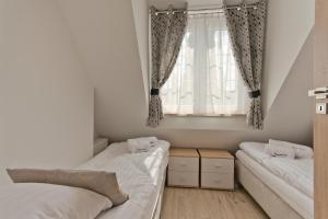 1 dormitorio con 2 camas y ventana en Apartamenty Gdańsk EU - Apartamenty Przy Piwnej II, en Gdansk