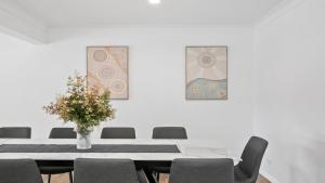 una mesa con sillas y un jarrón con flores en Seabreeze Escape, en Daleys Point 15 fotos más