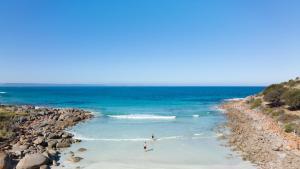 two people standing in the water on a beach at Sea Dragon Kangaroo Island in Antechamber Bay