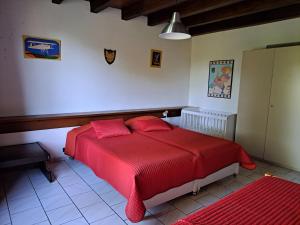 a bedroom with a red bed with red sheets at Comfortable holiday home with spacious garden in Ygrande