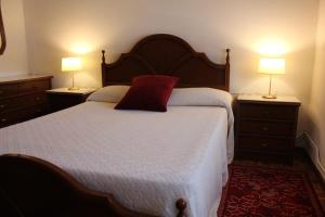 a bedroom with a bed with a red pillow on it at Apartamentos Picea Azul in Vega de Espinareda