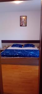a bed with blue sheets and a picture on the wall at Stefy Beach Apartment in Kavarna +26 photos
