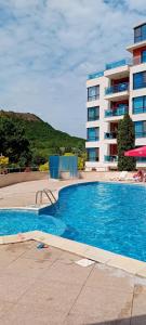a large swimming pool in front of a building at Stefy Beach Apartment in Kavarna