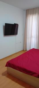 a bedroom with a bed and a flat screen tv at Stefy Beach Apartment in Kavarna