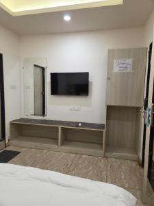 Zimmer mit einem Flachbild-TV an der Wand in der Unterkunft Hotel Kiwi Inn Reginoal Park in Indore + 22 Fotos