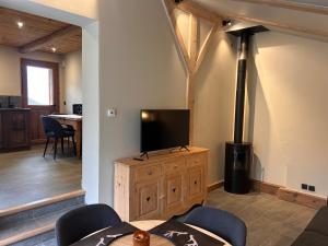 a living room with a flat screen tv on a wooden cabinet at Chalet Ulysse in Saint-Gervais-les-Bains