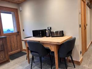 a wooden table with chairs and a microwave on it at Chalet Ulysse in Saint-Gervais-les-Bains +1 photo