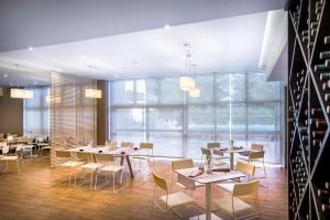 a dining room with tables and chairs and windows at Hotel Excelsior - Liburnia in Lovran