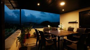 a table and chairs on a balcony with a view at The Solvista Villa 2hrs from Mumbai in Pali