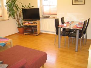 a living room with a dining room table and a television at Parahotel in Garmisch-Partenkirchen