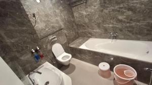 ein Badezimmer mit Waschbecken, Toilette und Badewanne in der Unterkunft Hotel Kiwi Inn Reginoal Park in Indore