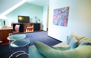 a living room with a couch and a table and a tv at Ressmann`s Residence in Kirkel