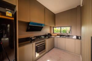 Ban Mae ChongにあるVanalux Garden Villa Chiangmaiのシンクとコンロのある小さなキッチン +4枚の写真