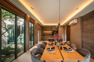 Ban Mae ChongにあるVanalux Garden Villa Chiangmaiのダイニングルーム(長い木製テーブル、椅子付)