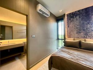 Ban Mae ChongにあるVanalux Garden Villa Chiangmaiのベッドと洗面台と鏡のある寝室