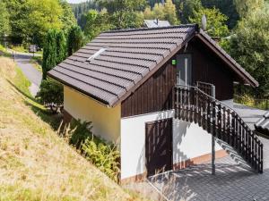a small house with a wooden roof and a balcony at Apartment near Rennsteig in Goldisthal +32 photos