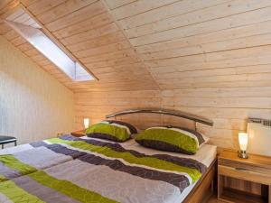 a bedroom with a bed with a wooden wall at Apartment near Rennsteig in Goldisthal