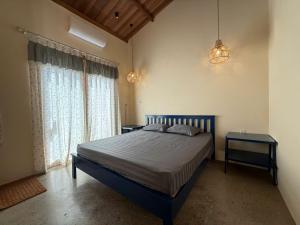 a bedroom with a bed with two tables and two windows at Tổ Ong Kiến Bình Định in Dương Liễu (2)