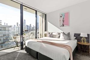 a bedroom with a large bed and a large window at Docklands Harbour View 3BR with Free Parking in Melbourne