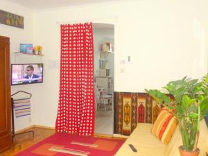 ブダペストにあるBZE Apartmentのリビングルーム(赤いカーテン、鏡付)