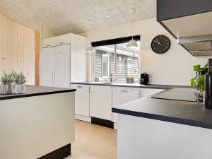 a kitchen with white cabinets and black counter tops at 5 star holiday home in Bogense in Bogense