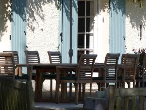 a wooden table and chairs sitting in front of a building at Labarthe in Baleyssagues