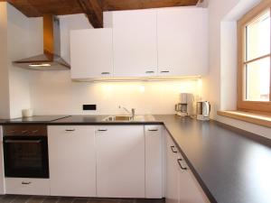 a kitchen with white cabinets and a sink at Chalet in Tyrol on St Johanns Ski Slope in Apfeldorf