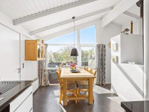 a kitchen with a wooden table and chairs in a room at 4 star holiday home in Hjørring in Kærsgård Strand
