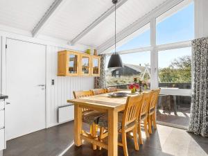 a dining room with a wooden table and chairs at 4 star holiday home in Hjørring in Kærsgård Strand