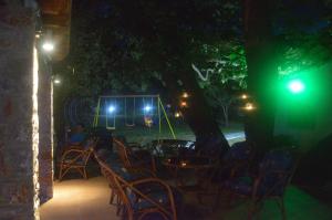 a group of chairs and tables in a yard at night at Hotel Zachos in Troulos
