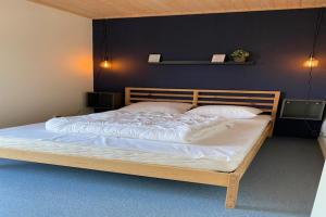 a bedroom with a large bed with white sheets at Chalet in Friesland near Alde Feanen Park in De Veenhoop