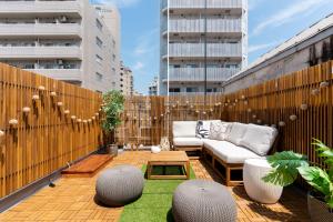 Un patio en la azotea con un sofá y una mesa. en 晴レ屋浅草 Hareya Asakusa, en Tokio