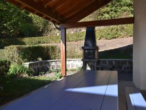 a wooden table with a wood stove on a patio at Holiday Home in Vosges with Garden and BBQ in Le Haut-du-Them