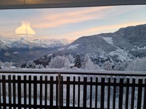 - une vue sur une montagne enneigée avec une clôture dans l'établissement Appartement Arolles 704, à La Tzoumaz